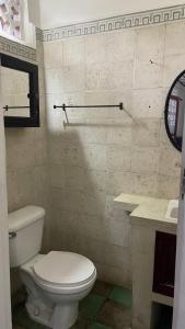 a bathroom with a white toilet and a sink at Casa Oasis Colonial in El Venado
