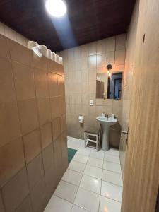 een badkamer met een wastafel, een toilet en een spiegel bij Casa da Gigi in Arraial do Cabo +8 foto's