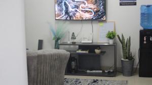 a living room with a chair and a tv on the wall at EnkishoniBnB Kitengela in Nairobi