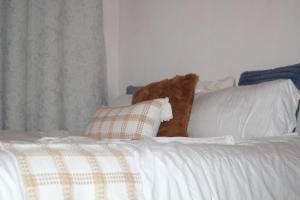 a teddy bear sitting on top of a white bed at EnkishoniBnB Kitengela in Nairobi