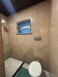 een badkamer met een toilet en een raam bij Casa da Gigi in Arraial do Cabo