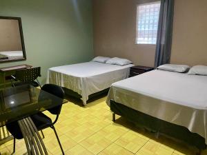a room with two beds and a desk and a mirror at La Casita in San Pedro Sula
