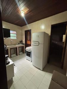 een keuken met een witte koelkast en een fornuis bij Casa da Gigi in Arraial do Cabo