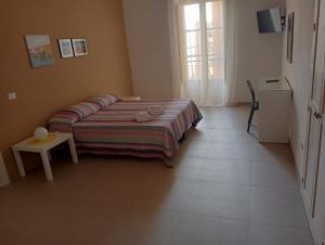 a bedroom with a bed and a table and a window at Penelope in Agrigento +2 photos