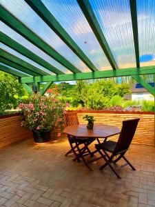 a patio with a table and chairs under a roof at Weingut Mathis Apartment 1 Burgblick in Klingenmünster