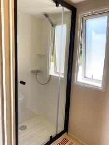 a shower in a bathroom with a window at Camping Le Solitaire du Lac in Saint-Jorioz