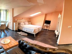 a bedroom with a bed and a couch in a room at Weingut Mathis Apartment 1 Burgblick in Klingenmünster