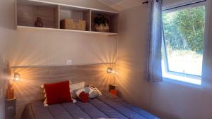 a bedroom with a bed with two pillows and a window at Camping Le Solitaire du Lac in Saint-Jorioz