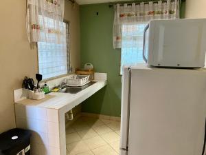 a kitchen with a sink and a refrigerator at La Casita in San Pedro Sula