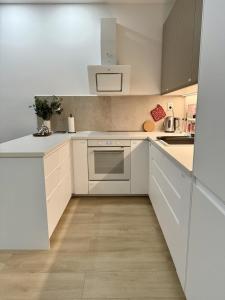 a white kitchen with white cabinets and appliances at Bratislava Cozy Corner Apartment in Vinohrady