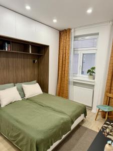 a bedroom with a large green bed and a window at Bratislava Cozy Corner Apartment in Vinohrady