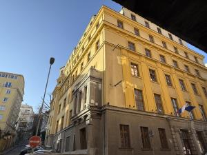 a yellow building on the side of a street at Bratislava Cozy Corner Apartment in Vinohrady