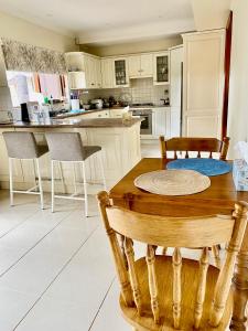 a kitchen with a wooden table and chairs in it at Hillside Retreat with Pool in Flagstaff Hill