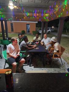 a group of people sitting at a table in a restaurant at Cozy Road Lodge in Sihangwane