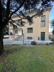 un grande edificio giallo con una porta verde di La Grande Casa di Malpensa - B&B a Gallarate