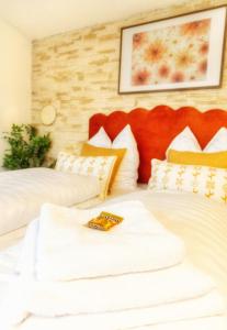 two beds with white sheets and a book on them at Zentrales Studio in Würzburg mit Dachterrasse und Tiefgarage in Würzburg