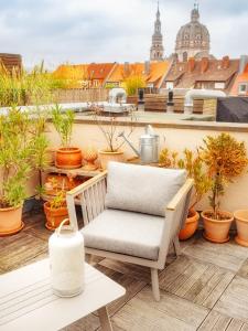 a chair sitting on top of a balcony with plants at Zentrales Studio in Würzburg mit Dachterrasse und Tiefgarage in Würzburg