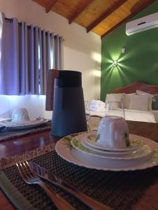 a table with plates and a juicer on top of it at Chalé Corina in Pirenópolis