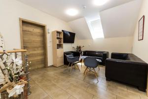 een woonkamer met een bank, een tafel en stoelen bij Comenius Moravus vinařský dvůr in Mikulov