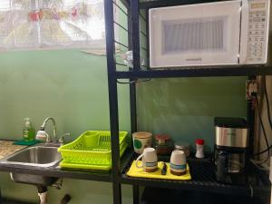 a kitchen with a sink and a microwave at Mini Suite Apartamento in San Pedro Sula +14 photos