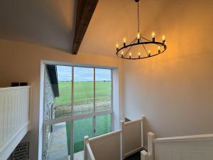 a chandelier in a hallway with a large window at The Barn in Skipton