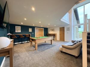 a living room with a pool table and some chairs at The Barn in Skipton