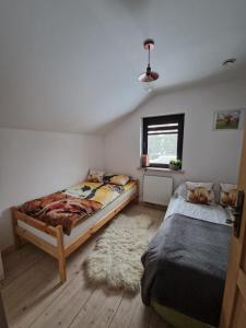 a bedroom with two twin beds and a rug at Domek pod Lasem in Bełchów