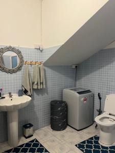 a bathroom with a sink and a toilet and a staircase at House Raghu in Rose Belle