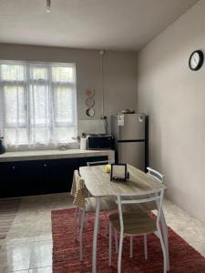 a kitchen with a table and chairs and a refrigerator at House Raghu in Rose Belle