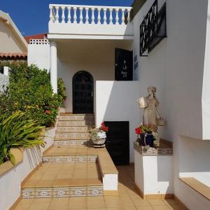 a courtyard of a house with stairs and flowers at Apartment La Casa Blanca in Playa del Hombre
