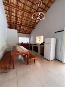 a large kitchen with a table and a refrigerator at Recanto das Águas in Cunha