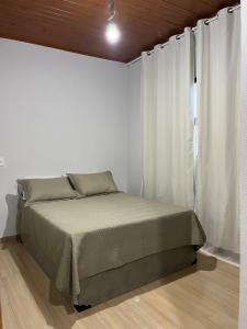 a bed in a white room with a window at Recanto das Águas in Cunha +22 photos
