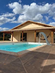 a pool with a water slide in front of a house at Recanto das Águas in Cunha