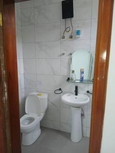 アクラにあるJudEls SA Guest Houseのトイレと洗面台を備えた白いバスルーム