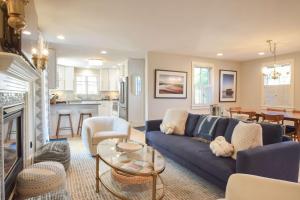 un soggiorno con un divano blu e una cucina di Private deck walk to Commercial Street a Provincetown