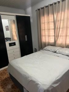 a bedroom with a large bed and a dresser at Casa Vidro Mar in Bombinhas