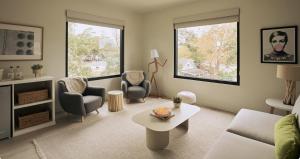 a living room with a couch and two windows at Hotel Circulo in Charleston