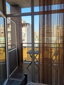 a balcony with a table and a view of a city at Ia's Home in Tbilisi City