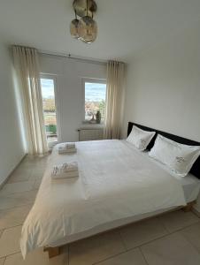 a bedroom with a large bed with white sheets and pillows at Ferienwohnung Allegra in Heinsberg