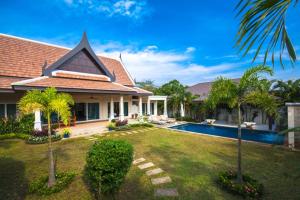 a house with a yard with a swimming pool at Noksawan Villa by G Estate in Rawai Beach