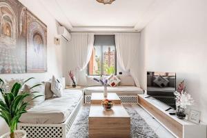 een woonkamer met twee banken en een tafel bij Modern Elegance & Moroccan Charm - Gueliz Center in Marrakesh