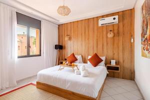 een slaapkamer met een wit bed met een houten wand bij Modern Elegance & Moroccan Charm - Gueliz Center in Marrakesh