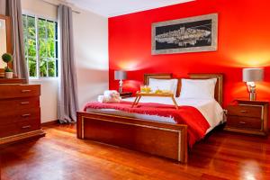 a red bedroom with a bed with a red wall at View to the Valley, By OP in Senhora do Rosário