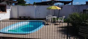 a swimming pool with a table and an umbrella at Casa Ximendes in São Gabriel