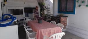 a man standing on a patio with a table and chairs at Casa Ximendes in São Gabriel +4 photos