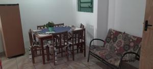 a dining room with a table and chairs and a couch at Casa Ximendes in São Gabriel