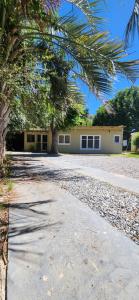 a house with a palm tree in front of a driveway at Moramay in Punta del Este