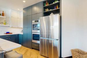 a kitchen with blue cabinets and a stainless steel refrigerator at The 19th Hole in Sturgis