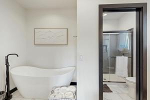a white bathroom with a tub and a toilet at The 19th Hole in Sturgis +44 photos