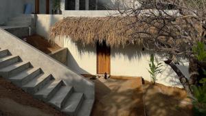 a staircase leading to a building with a thatch roof at Lalito in Zipolite